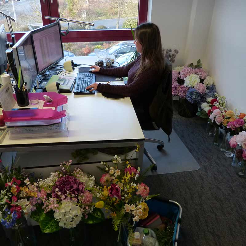 Schoenster-Computer-Arbeitsplatz-von-Blumenstraeussen-umringt